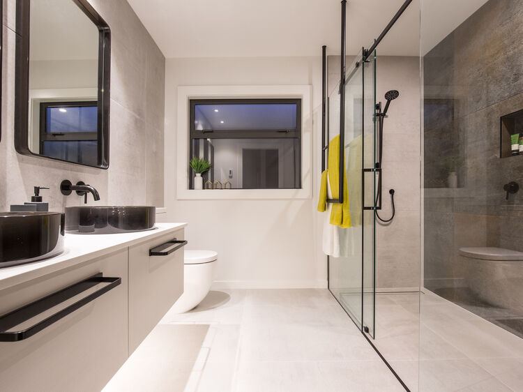 Modern bathroom with dual black basins and a large glass shower.
